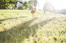 children running and jumping in grass