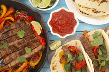 Beef Fajitas with Bell Peppers on a Bright Blue Wood Table