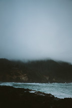 fog over cliffs along a shoreline 