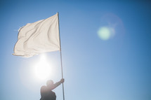 A man carrying a white flag of surrender