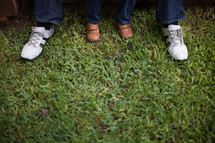 feet of a father and son in grass