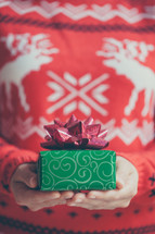 a woman holding a wrapped Christmas gift 