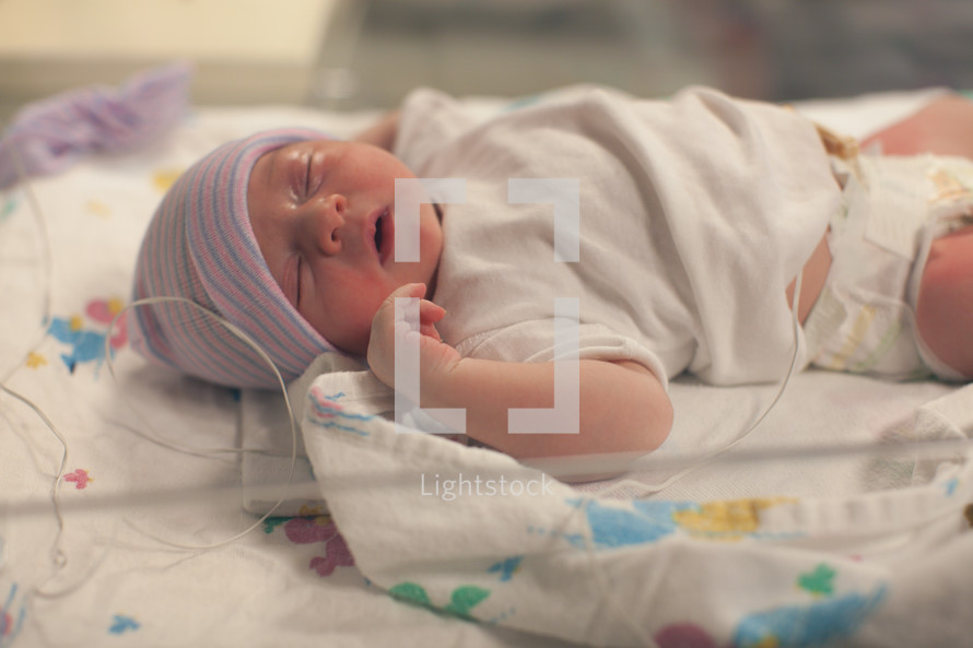 a newborn baby in a hospital bed 
