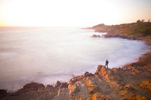 distant man standing on a rocky shore