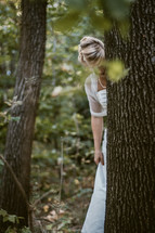 bride behind a tree in a forest 