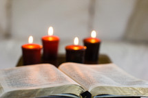 open Bible and burning candles