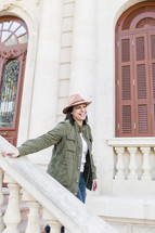 Portrait of a woman walking down the steps of a building smiling.