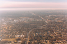 aerial view over suburbs and roads below 