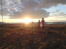 kids playing on a beach at sunset 