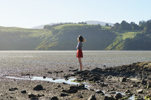 teen standing on a shore looking out 