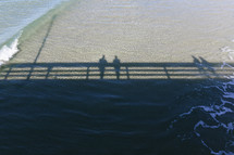 shadows of a pier on ocean water 