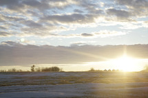 sunrise over a snow covered field 