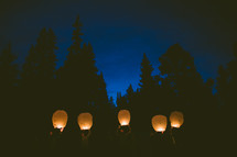 about to release paper lanterns into the night sky