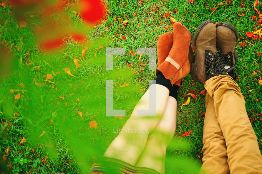 couples feet and shoes in the grass