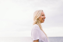 side profile of a blonde woman standing by the ocean 