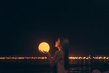 a woman holding a glowing orb 