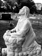 statue of Jesus praying in a cemetery 