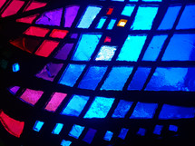 Stained glass window with blue, pink, purple and red shades of color