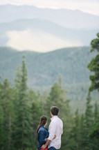 couple hugging standing in a forest 