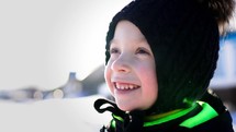 Winter time, happiness childhood. Happy boy play in a beautiful winter park. Cute kid having fun at winter holidays. Healthy lifestyle concept.