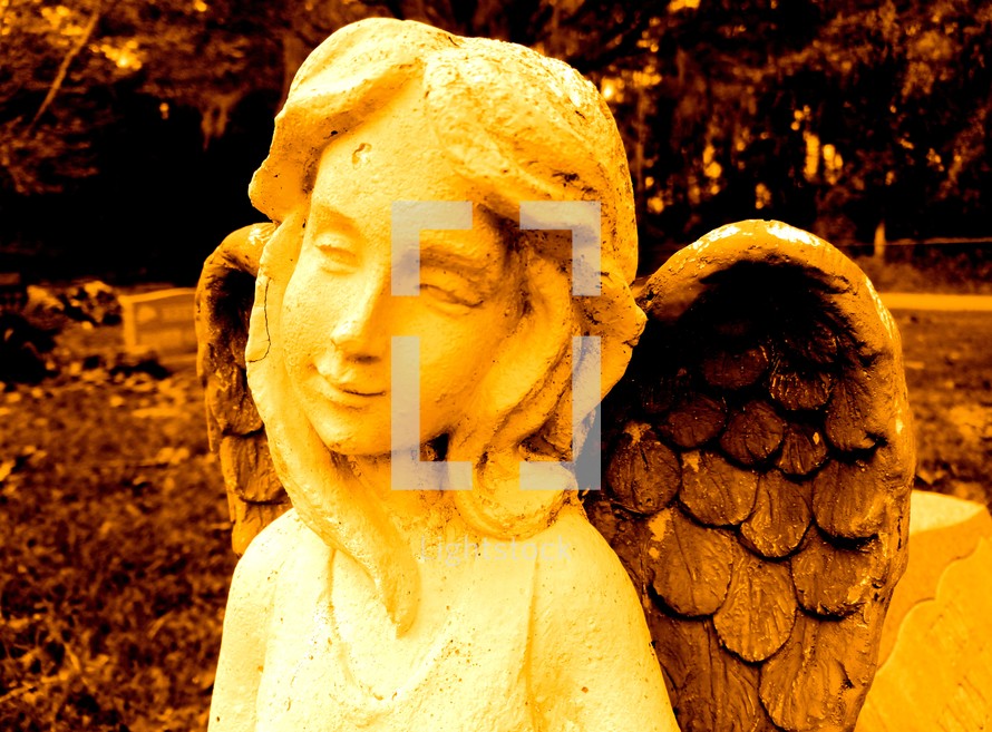 Yellow smiling angel in a graveyard
