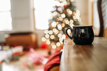 bokeh Christmas lights and mug on a wood table 