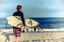 a man carrying a surfboard on a beach 
