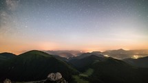 Day to night, sunset to starry night in mountains time-lapse with milky way galaxy stars moving over countryside traffic
