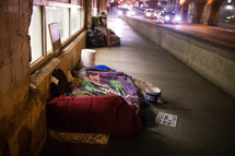 homeless sleeping bags on a city sidewalk 