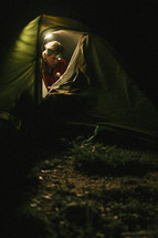 a woman in a tent with a headlamp 
