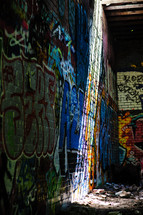 rays of sunlight shining on a graffiti covered wall 
