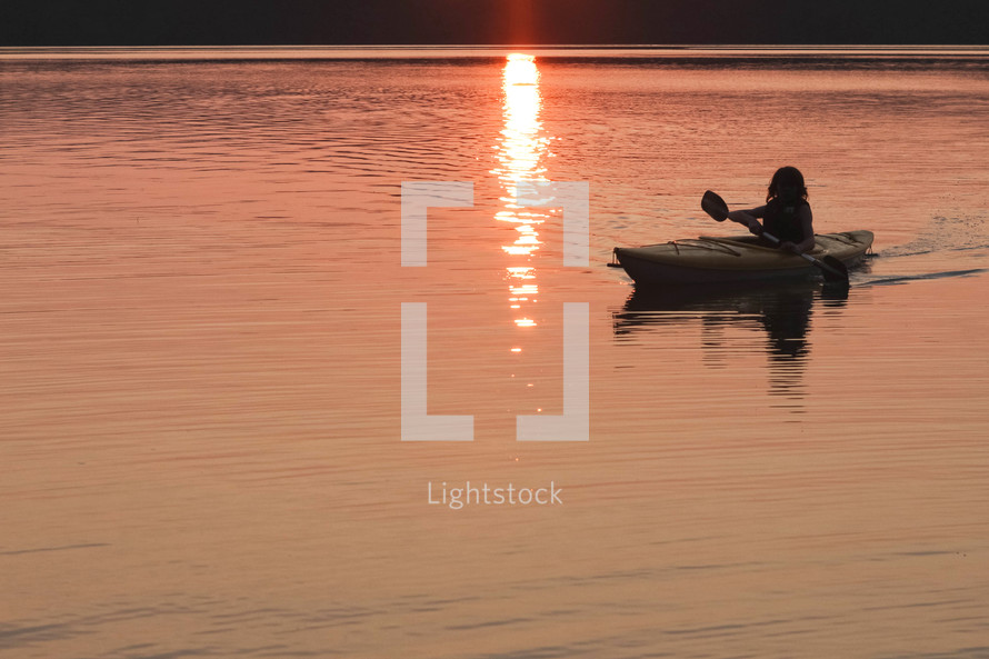 a kayak on a lake at sunset 