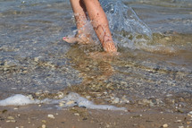 feet splashing in lake water