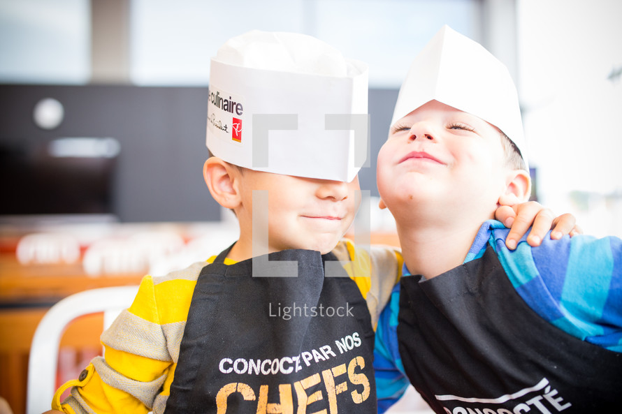 brothers in paper hats at a cooking class 