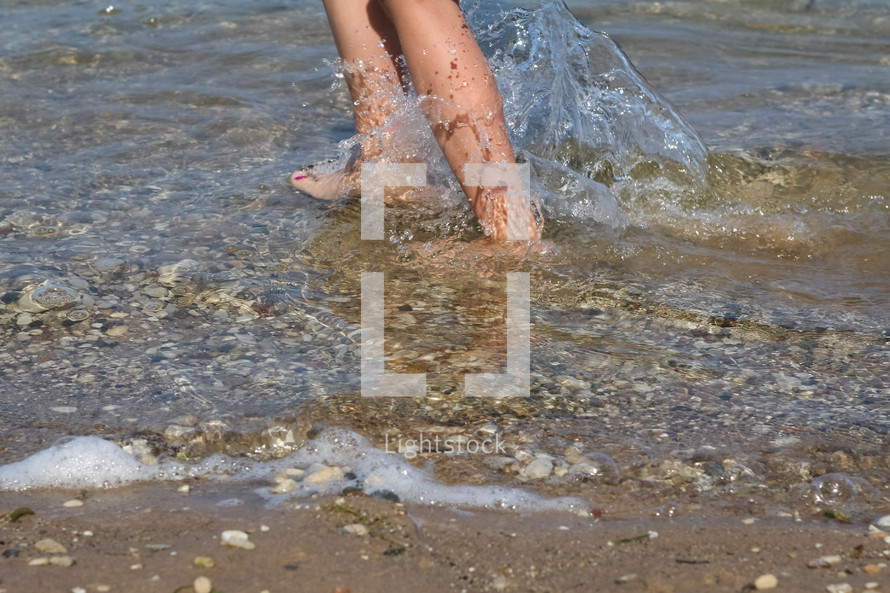 feet splashing in lake water