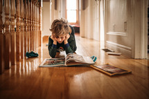 a child reading a book on the floor 