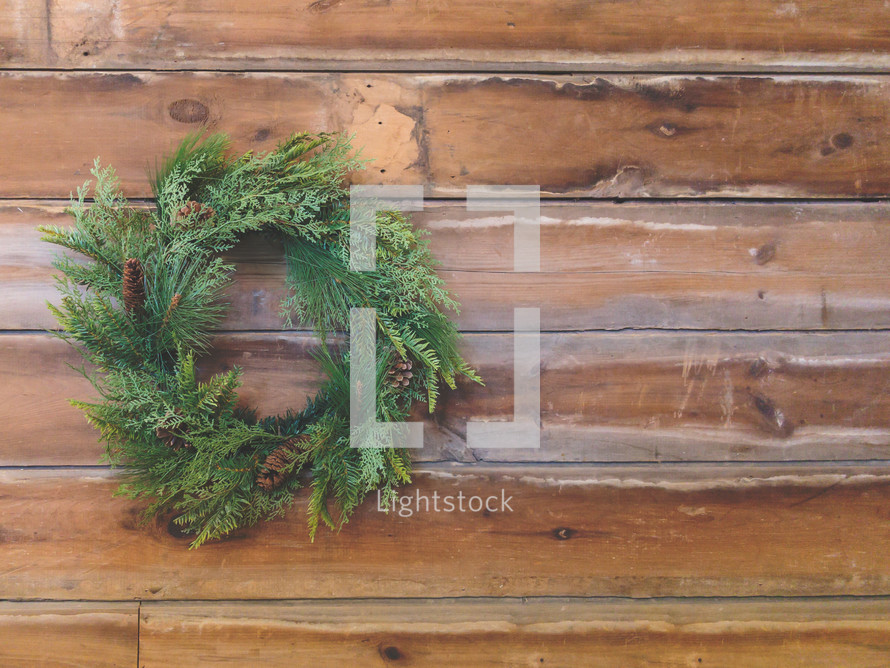 Christmas pine wreath stock photo on farmhouse wood background ideal for a social media post idea, slide presentation background like powerpoint or keynote, church bulletin and more