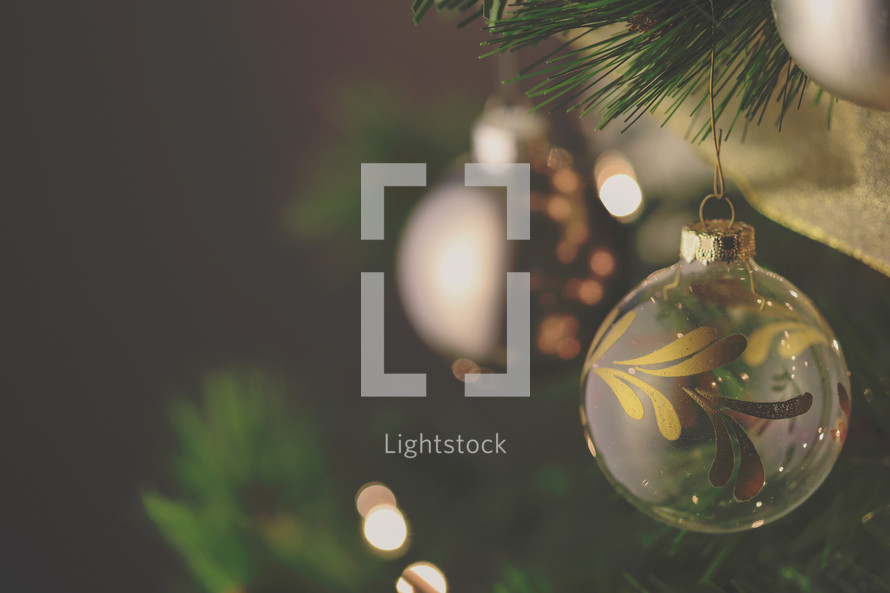 Christmas tree stock photo with an ornament and bokeh Christmas lights ideal for a social media post idea, presentation slide background or church bulletin cover.