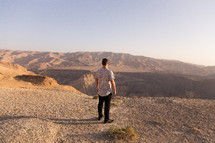 a man looking out at a desert landscape 