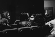 women talking in auditorium seats