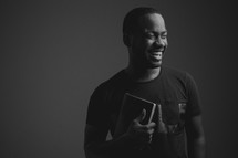 man holding a Bible and smiling 