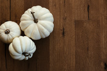 white pumpkins on a wood floor 