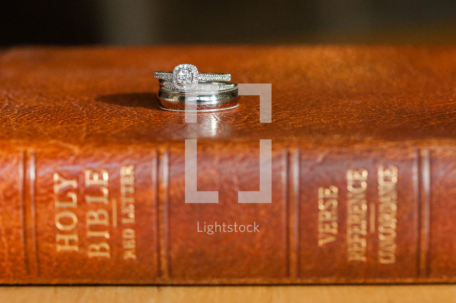 engagement ring and wedding band on a Bible 