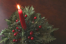 red Christmas candle against a wood background 