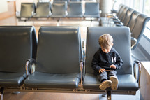a boy child sitting in a waiting area 