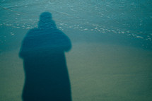 shadow of a man standing over the tide 