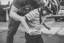 dad helping his son rollerblade 