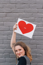woman holding a picture of a heart that says hello 