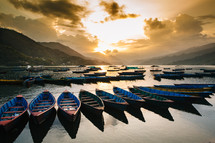 boats anchored in a harbor at sunrise 