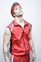 Kevin Fitness; man in red workout wear; red headband, vest, shorts.